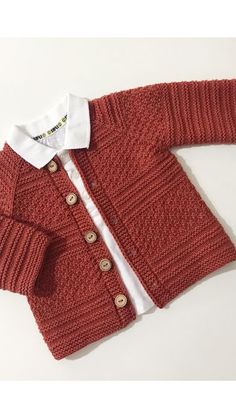 a red cardigan sweater with buttons on the collar and sleeves, sitting on a white surface