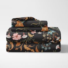 the black floral sheet set is folded on top of each other