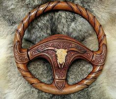 the steering wheel is made out of wood and has an animal's head on it