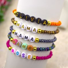 a stack of bracelets with the words mamma and rose written on them in different colors