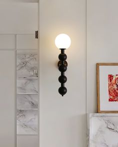 a wall light mounted on the side of a white wall next to a marble counter