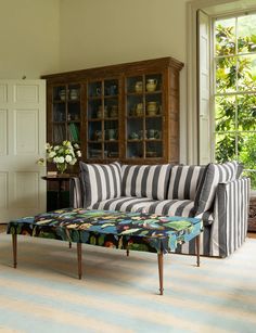 a living room with a striped couch and coffee table