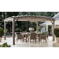 an outdoor dining table and chairs under a pergolated gazebo with potted plants