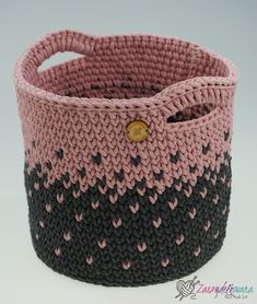 a pink and black knitted basket sitting on top of a table