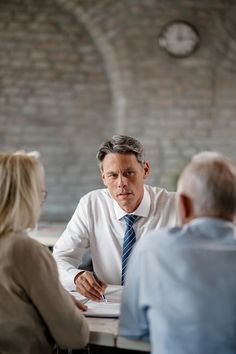 two men and a woman sitting at a table