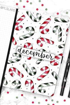 an open notebook with christmas candy canes and the word december written in black ink