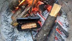 there is a fire pit with some food cooking on it and two sticks sticking out of it