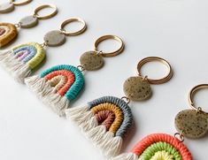 a row of multicolored tasselled keychains on a white surface