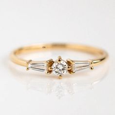 a yellow gold ring with three stones on the side and one stone in the middle