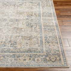 an area rug on the floor with wood floors in the background and a wooden floor