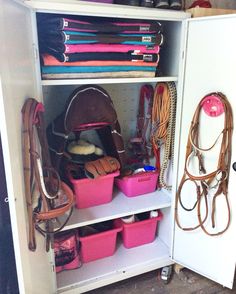 the inside of a closet filled with lots of pink containers and brown bags on top of white shelves