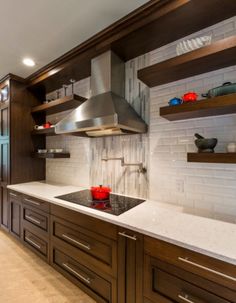 a kitchen with wooden cabinets and white counter tops, along with a stainless steel range hood