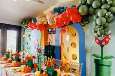 a table set up for a birthday party with balloons and decorations on the wall behind it