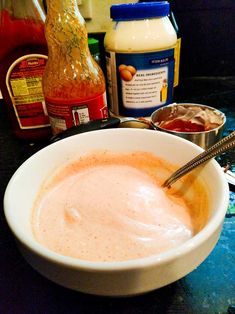 a white bowl filled with liquid next to some condiments