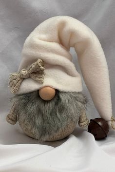 a stuffed animal with a hat on it's head and a nut in the other hand