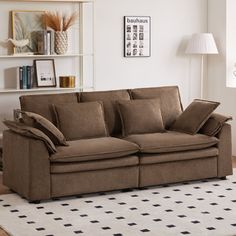 a brown couch sitting on top of a rug in a living room