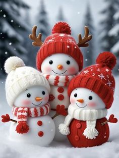 three snowmen with hats and scarfs in the snow