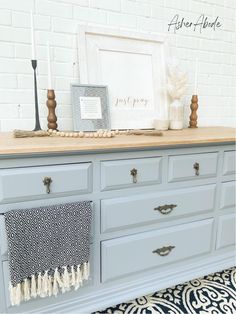 a dresser with drawers and pictures on top