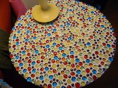 the table is made out of plastic balls and has a yellow vase on top of it