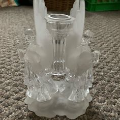 a glass candle holder sitting on top of a carpeted floor