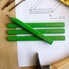 three green pencils sitting on top of a piece of paper