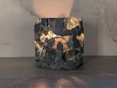 a candle that is sitting on top of a table next to a vase with rocks in it