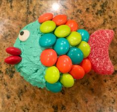 a cupcake shaped like a fish with candy on it