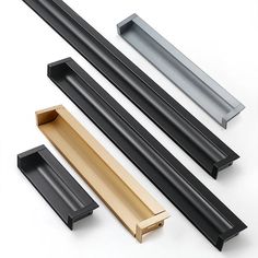 three different types of black and gold door handles on a white surface with one open