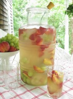 there is a glass full of fruit on the table