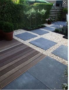 an outdoor area with wooden decking and plants