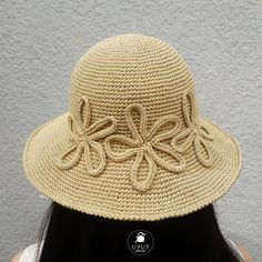 a woman wearing a straw hat with an intricate bow on the brim and side