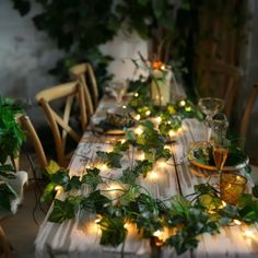 the table is covered with greenery and lit candles