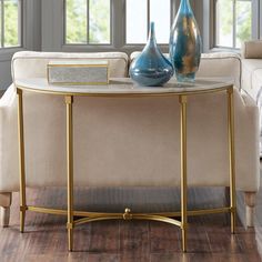 two vases sitting on top of a white table next to a couch in a living room