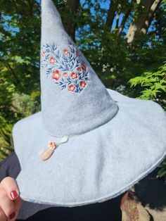 a woman wearing a gray hat with flowers on it