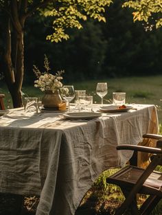 the table is set with wine glasses and plates