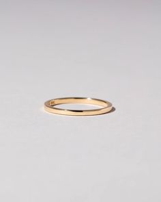 a plain gold wedding ring on a white background with space for the word, i love you