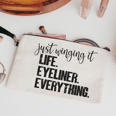 a bag that says just wrong at life, eyeliner everything on the table next to it