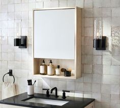 a bathroom with a sink, mirror and soap dispenser on the wall