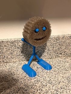 a blue and brown toy standing on top of a counter next to a white wall