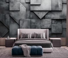 a bed sitting in front of a wall covered in grey squares and shapes on it