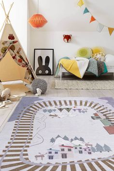 a child's bedroom with a teepee tent, bed and rugs on the floor