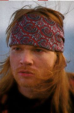 a man with long hair wearing a bandana