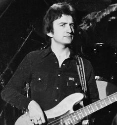 a black and white photo of a man playing an electric guitar