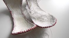 two pairs of white shoes with red and white lace