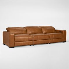 a brown leather couch sitting on top of a white floor