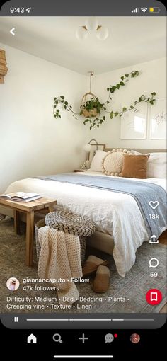 a bed room with a neatly made bed and plants hanging on the wall above it