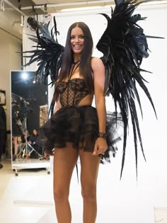 a woman in a corset and wings poses for the camera