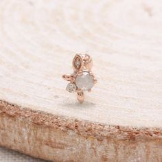 a close up of a ring on top of a piece of wood with a stone in the middle