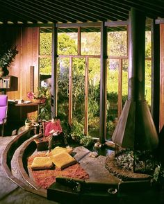 a living room filled with furniture and a fire place in front of a large window