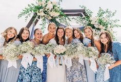 a group of women standing next to each other with bouquets in front of them